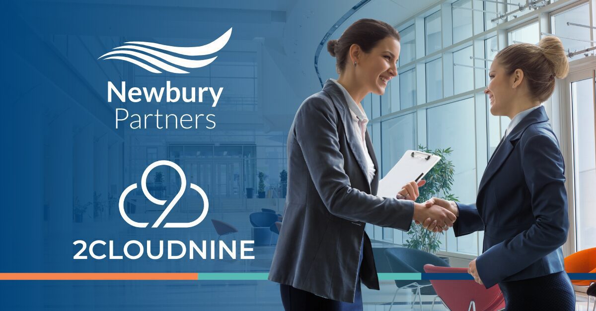 Two business professionals shake hands in front of a large window, symbolizing a successful partnership or agreement.