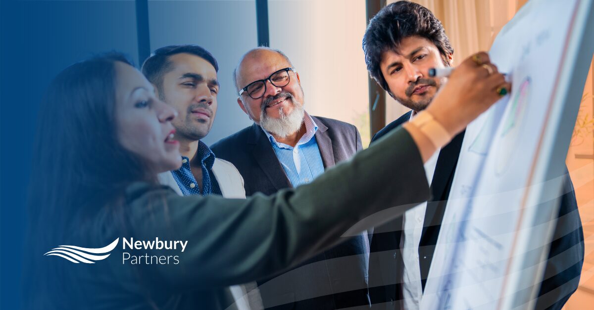 Team collaborating on whiteboard to develop scaling staffing technology implementation plan.