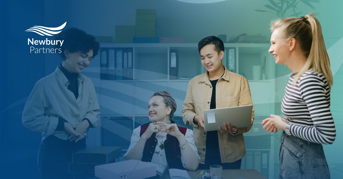 Team collaborating on staffing implementation roadmap with laptop during strategic planning session.