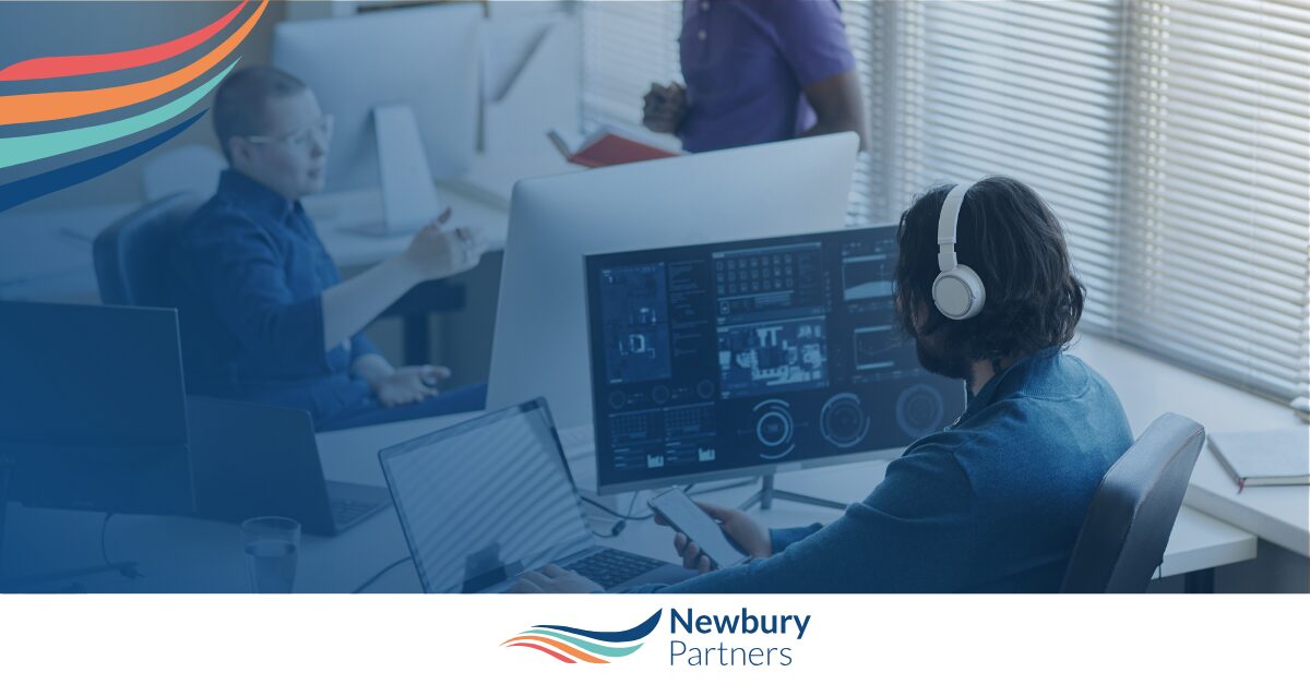 Professional analyzing staffing automation ROI data on multi-screen analytics dashboard at workstation.