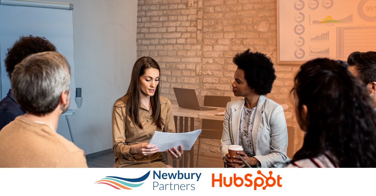 Staffing professionals discussing HubSpot ROI projections and analytics in team meeting.